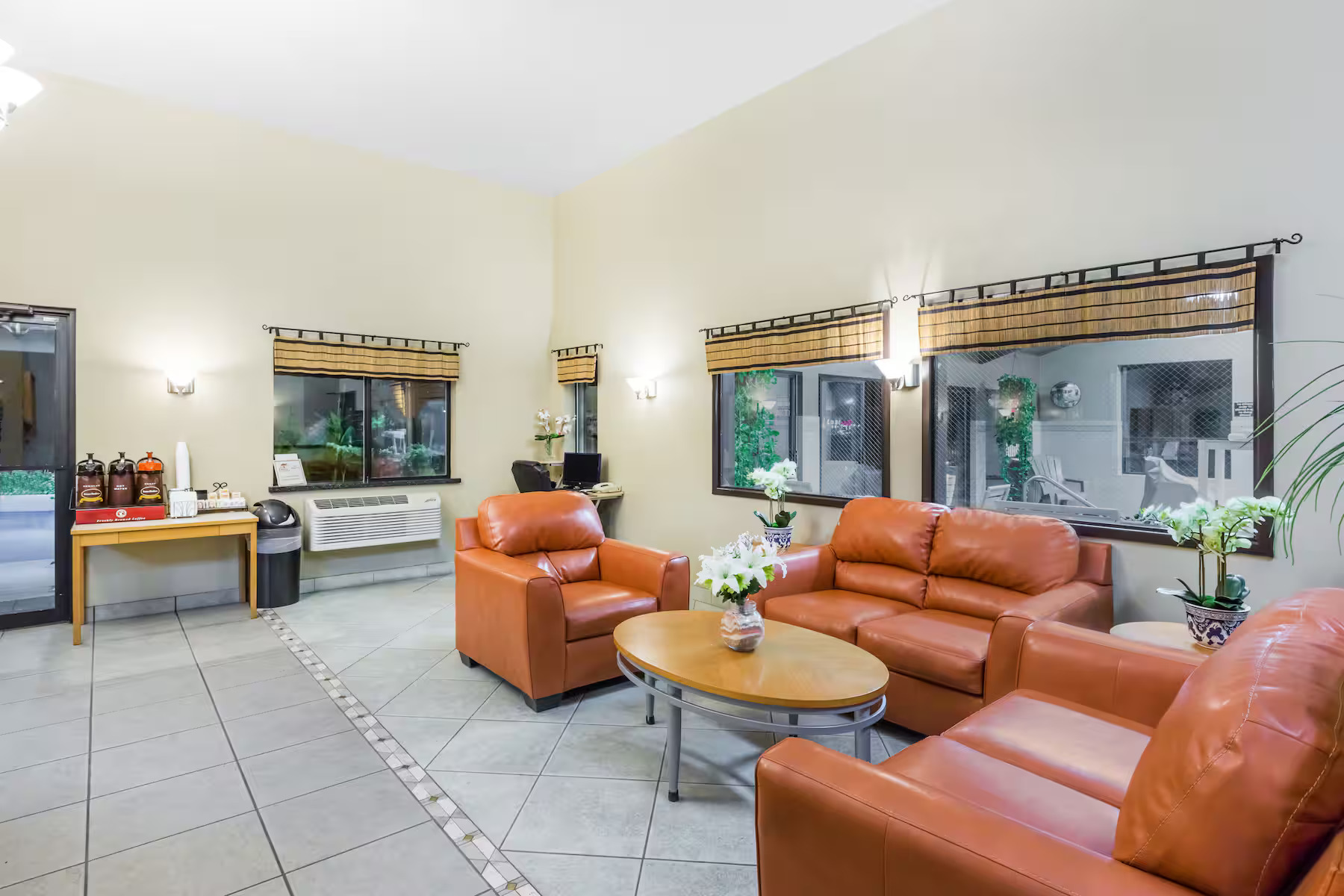 Person kayaking on a lake surrounded by pine trees and snow-capped mountains under a cloudy sky